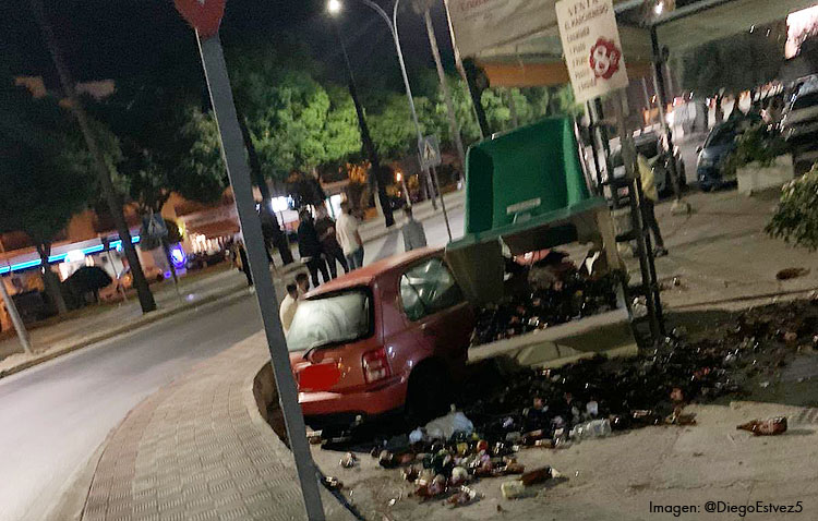 Pierde el control del coche, atraviesa la acera y acaba empotrado en un contenedor de vidrio junto a la terraza de un bar