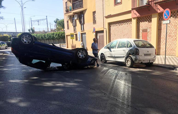 Un aparatoso accidente deja a un coche boca abajo tras colisionar con otros dos turismos en Utrera