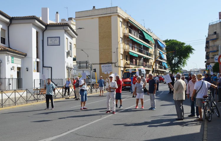 Un grupo de mayores corta el tráfico en la avenida Juan XXIII para reclamar una ampliación del horario del Hogar del Pensionista de Utrera